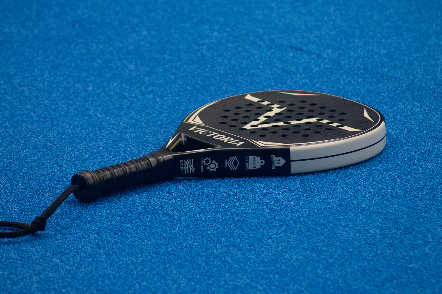 victoria padel rond round racket 3k carbon zwart wit productfoto zijkant blauwe achtergrond